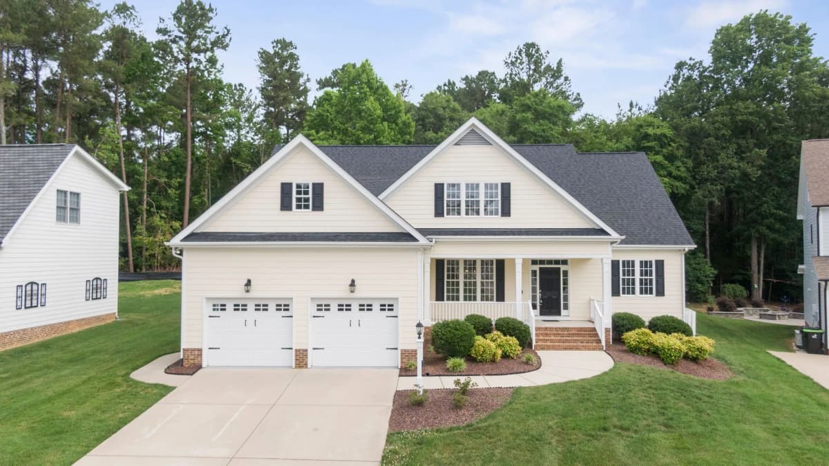 White home with a two-car garage and a landscaped front yard